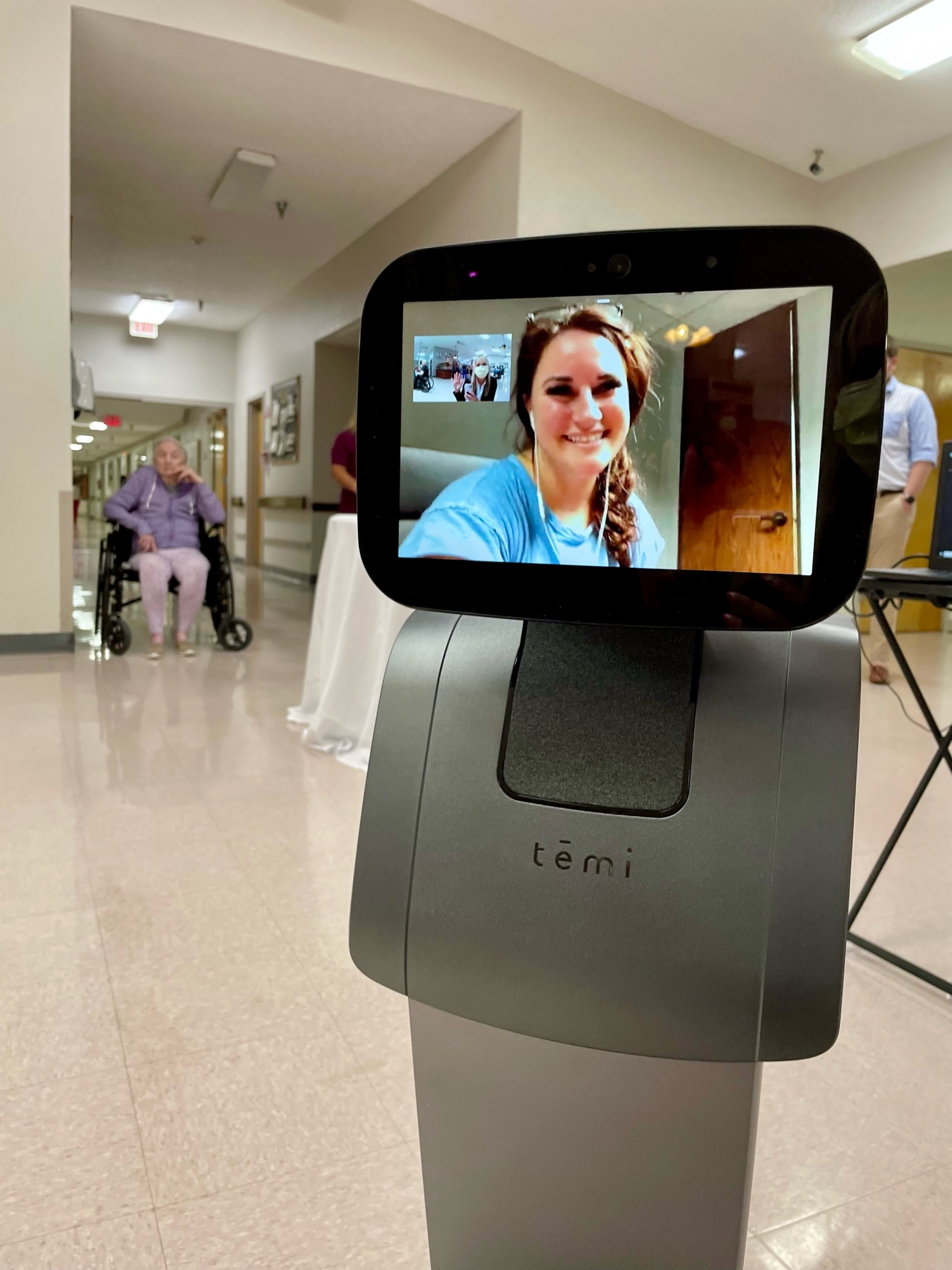 Robot with a smiling woman on the display screen