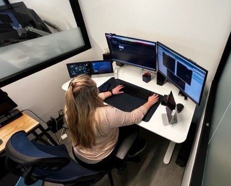 A remote-support monitor is sitting in front of her office computer.
