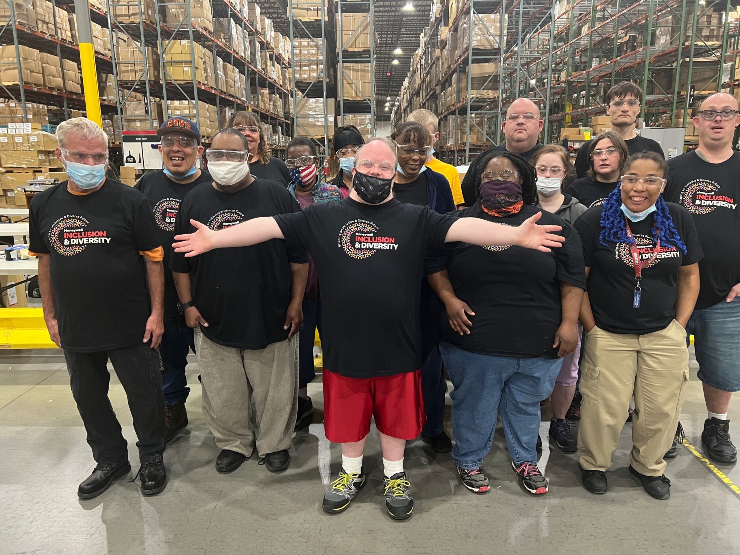 Group of workers standing and smiling inside Honeywell warehouse