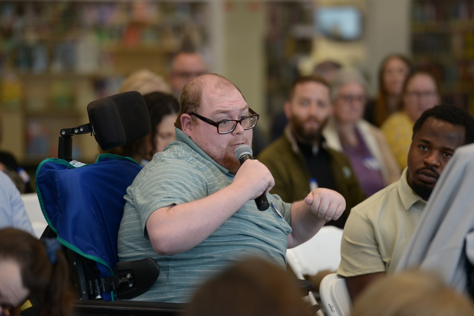 man in wheelchair speaking into microphone